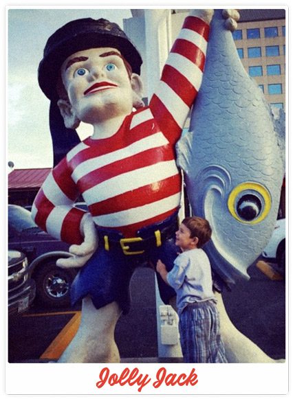 Young child hugging Jolly Jack statue outside Sea Island Shrimp House on Rector